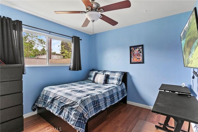 bedroom with baseboards, ceiling fan, and wood finished floors