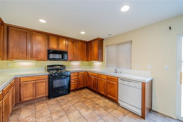 14051 Mare Ln, Victorville, CA 92394 - kitchen featuring black appliances, brown cabinetry, recessed lighting, and tile counters