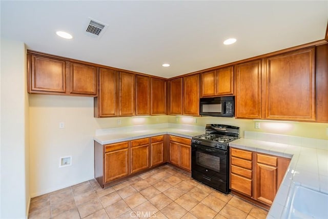 14051 Mare Ln, Victorville, CA 92394 - kitchen featuring black appliances, brown cabinetry, tile counters, and recessed lighting