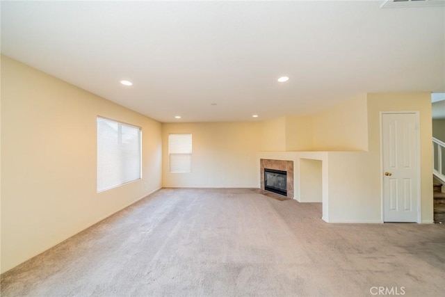 14051 Mare Ln, Victorville, CA 92394 - unfurnished living room with light colored carpet, a tiled fireplace, stairs, and recessed lighting