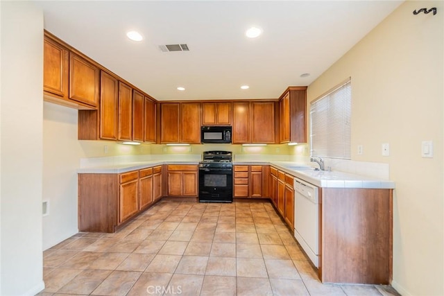 14051 Mare Ln, Victorville, CA 92394 - kitchen featuring black appliances, light countertops, brown cabinets, and recessed lighting