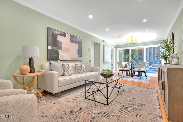 living area featuring an inviting chandelier, ornamental molding, light wood-style floors, and recessed lighting