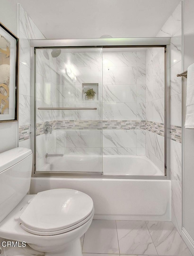 bathroom featuring toilet, marble finish floor, and shower / bath combination with glass door