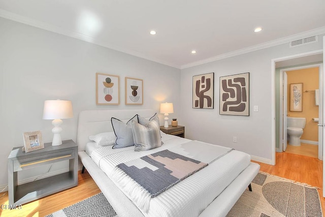 bedroom featuring visible vents, light wood-type flooring, crown molding, and baseboards