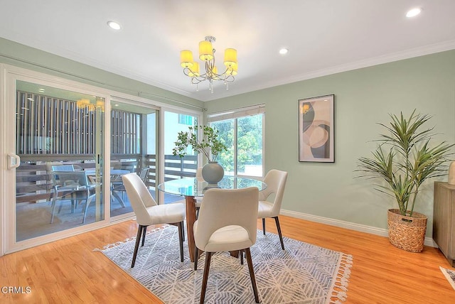 dining area featuring a chandelier, light wood-type flooring, crown molding, and baseboards