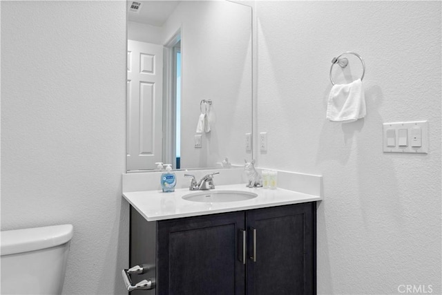 3308 Jack Rabbit Ct, Perris, CA 92570 - bathroom featuring a textured wall, visible vents, toilet, and vanity
