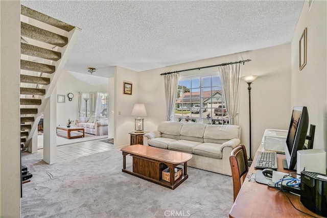 carpeted living area featuring a textured ceiling and stairway
