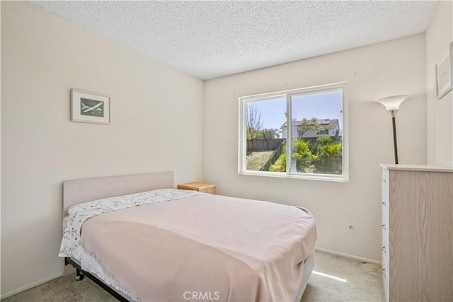 bedroom with carpet floors, a textured ceiling, and baseboards