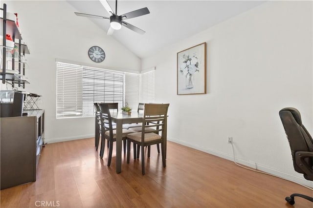 dining room with high vaulted ceiling, wood finished floors, a ceiling fan, and baseboards