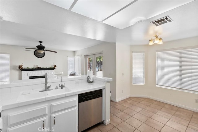 kitchen with visible vents, tile countertops, stainless steel dishwasher, a sink, and ceiling fan