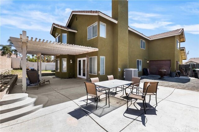 rear view of house featuring central AC unit, a pergola, french doors, fence, and stucco siding
