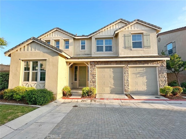 craftsman house with a garage, board and batten siding, stucco siding, and stone siding
