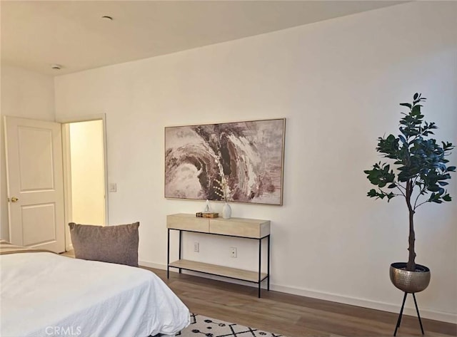 bedroom featuring baseboards and wood finished floors