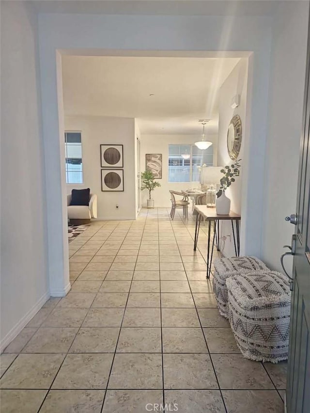 hall featuring light tile patterned floors and a wealth of natural light