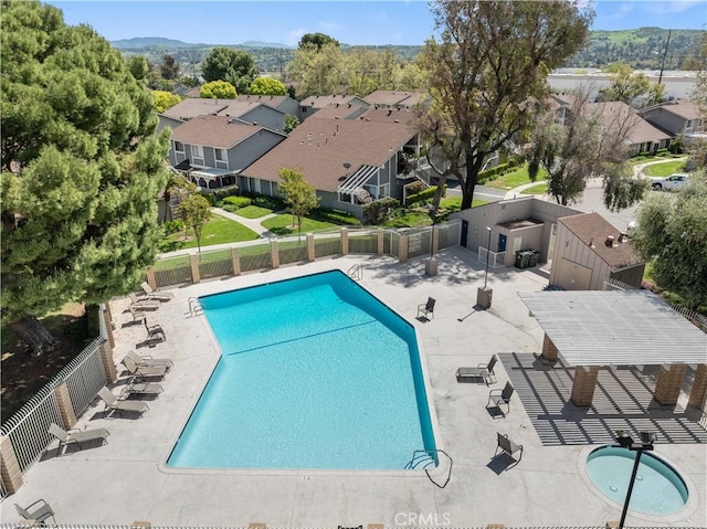 pool with a patio area, fence, a residential view, and a mountain view