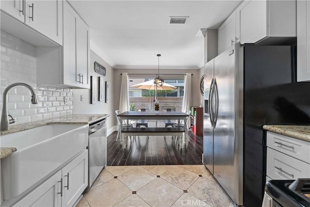 kitchen featuring a sink, visible vents, white cabinetry, appliances with stainless steel finishes, and ornamental molding