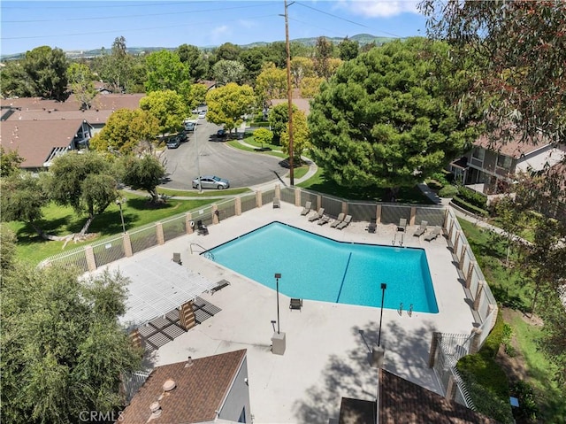 pool with a patio and fence