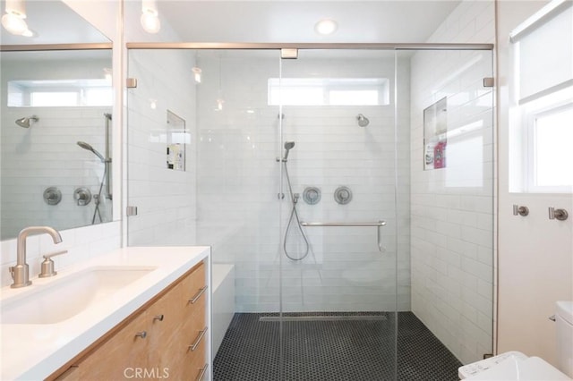 full bath with toilet, vanity, and a healthy amount of sunlight