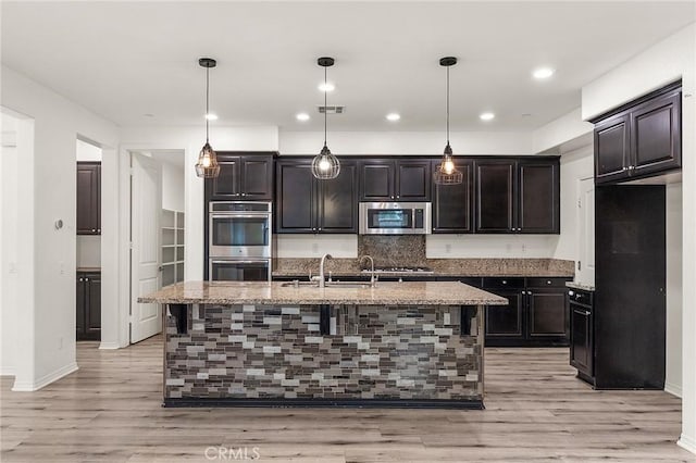 37544 River Oats Ln, Murrieta, CA 92563 - kitchen with tasteful backsplash, appliances with stainless steel finishes, baseboards, and light stone counters