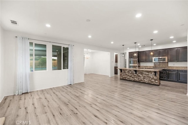 37544 River Oats Ln, Murrieta, CA 92563 - unfurnished living room featuring a sink, a chandelier, light wood finished floors, visible vents, and recessed lighting