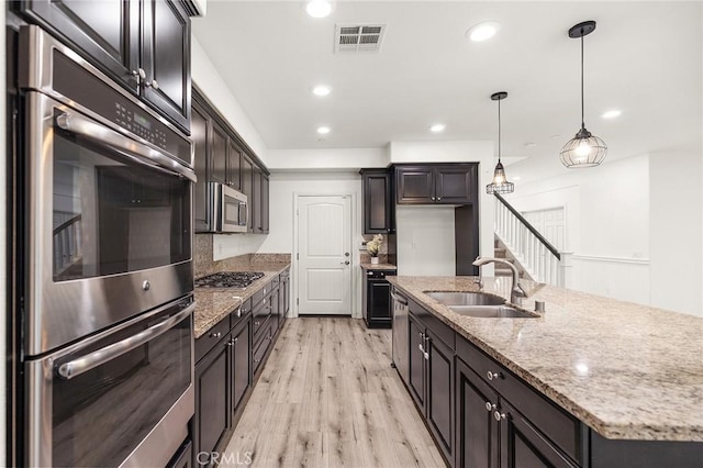 37544 River Oats Ln, Murrieta, CA 92563 - kitchen with light wood-style flooring, a sink, visible vents, decorative light fixtures, and appliances with stainless steel finishes