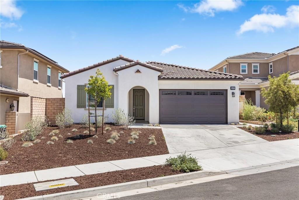 463 Harding Cir, Corona, CA 92879 - mediterranean / spanish-style house featuring an attached garage, a tiled roof, driveway, and stucco siding