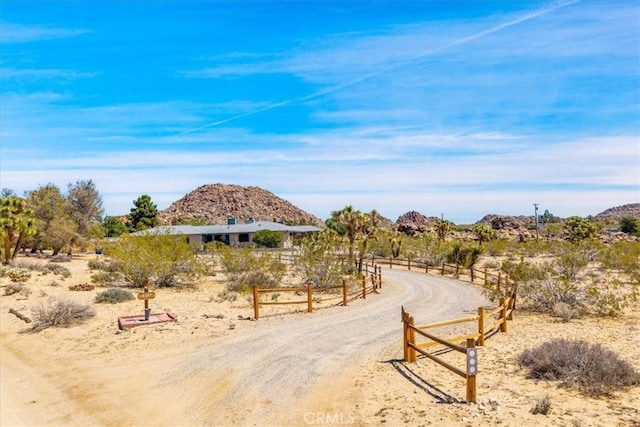 surrounding community with fence, a mountain view, and a rural view
