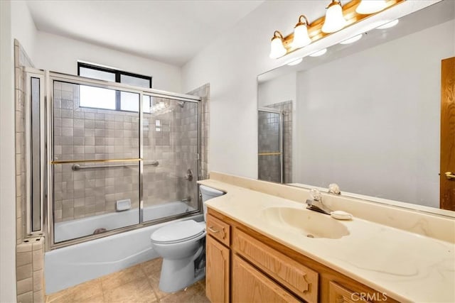 full bath with vanity, bath / shower combo with glass door, tile patterned floors, and toilet