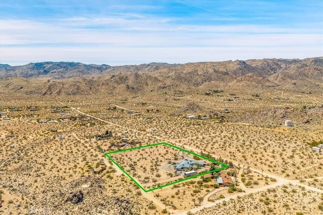 drone / aerial view featuring a mountain view, view of desert, and a rural view