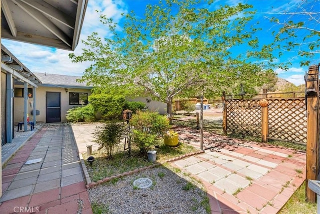 view of yard featuring fence and a patio area
