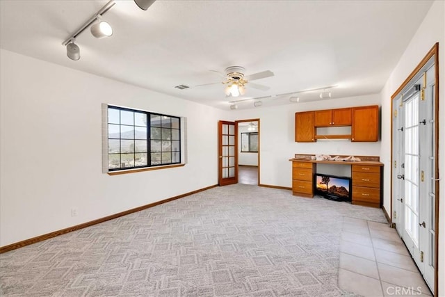 unfurnished living room with track lighting, ceiling fan, visible vents, and french doors
