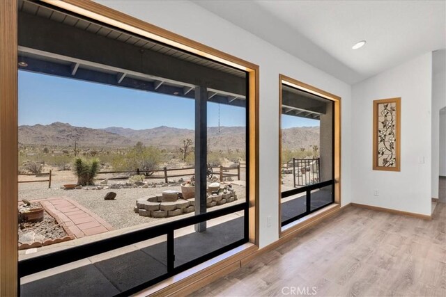 entryway with baseboards, a mountain view, and wood finished floors