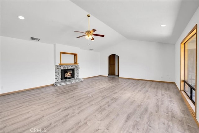unfurnished living room featuring ceiling fan, visible vents, arched walkways, vaulted ceiling, and light wood finished floors