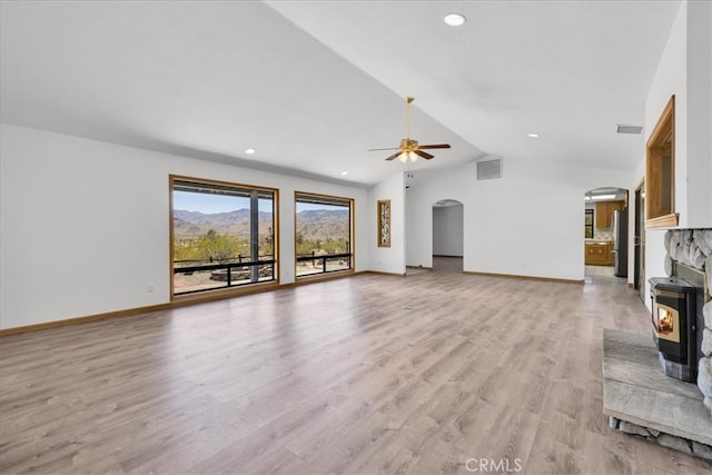 unfurnished living room featuring arched walkways, ceiling fan, vaulted ceiling, and visible vents