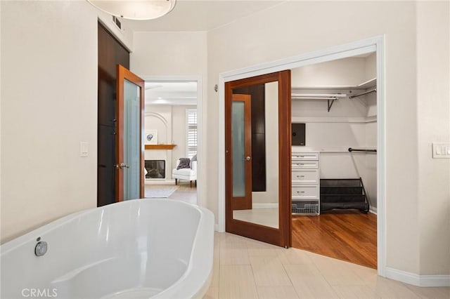 804 N Juanita Ave Unit B, Redondo Beach, CA 90277 - full bathroom with a glass covered fireplace, baseboards, a freestanding tub, and a spacious closet