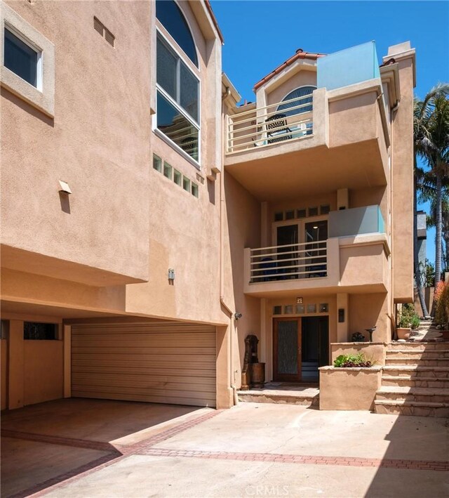 804 N Juanita Ave Unit B, Redondo Beach, CA 90277 - townhome / multi-family property with stucco siding, an attached garage, concrete driveway, and a balcony