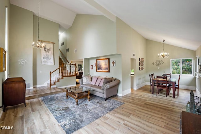 living room with light wood finished floors, a notable chandelier, stairway, and high vaulted ceiling