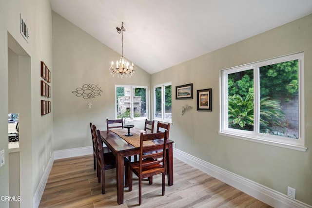 dining area with light wood-type flooring, plenty of natural light, a notable chandelier, and baseboards