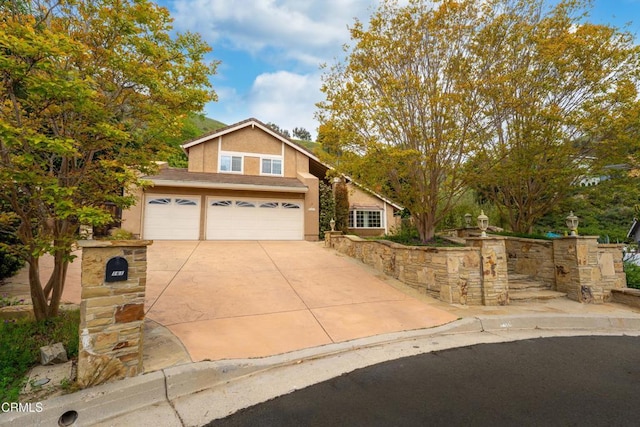 view of front of house with concrete driveway, a garage, and stucco siding