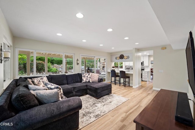 living area with light wood finished floors and recessed lighting