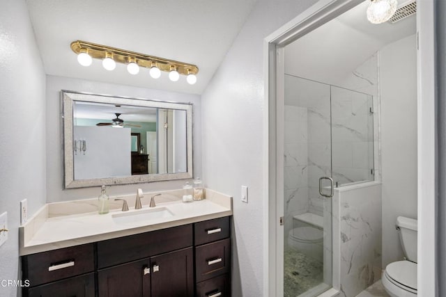 bathroom featuring toilet, a marble finish shower, ceiling fan, and vanity