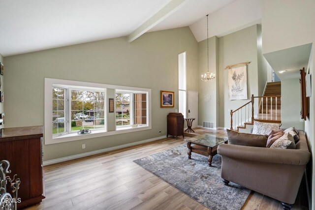 living room featuring wood finished floors, stairway, a chandelier, visible vents, and high vaulted ceiling