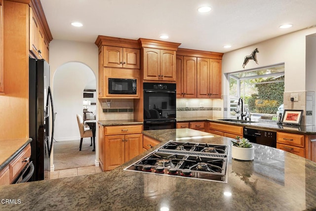 1894 Rambling Rd, Simi Valley, CA 93065 - kitchen featuring black appliances, arched walkways, decorative backsplash, recessed lighting, and dark stone counters