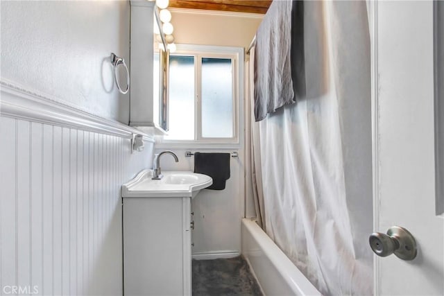 full bathroom with shower / bath combination with curtain, vanity, and a wainscoted wall