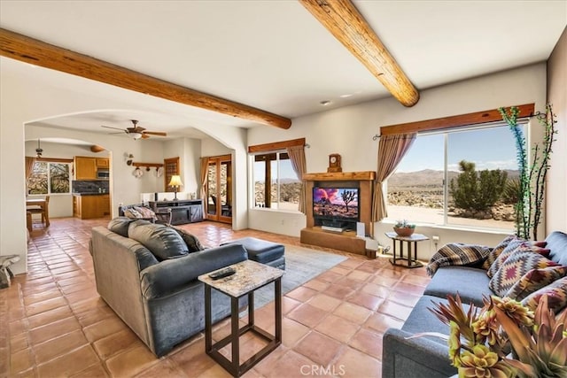 57710 Bandera Rd, Yucca Valley, CA 92284 - living room with a wealth of natural light, beamed ceiling, light tile patterned floors, and arched walkways