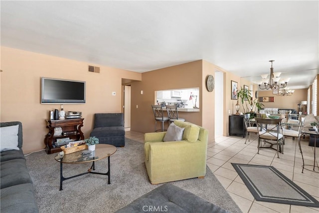 living room with visible vents, a notable chandelier, and light tile patterned flooring