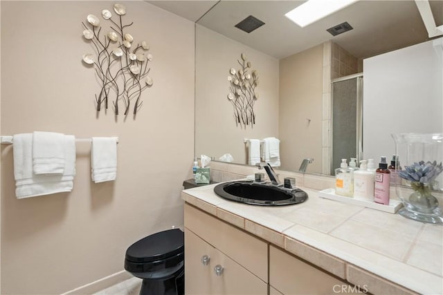 full bath with visible vents, a stall shower, toilet, and vanity