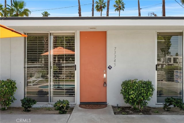 property entrance with stucco siding