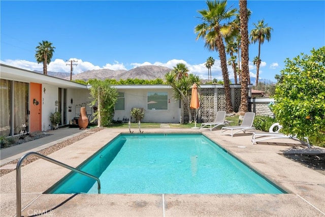 view of swimming pool with a fenced in pool, a mountain view, and a patio area