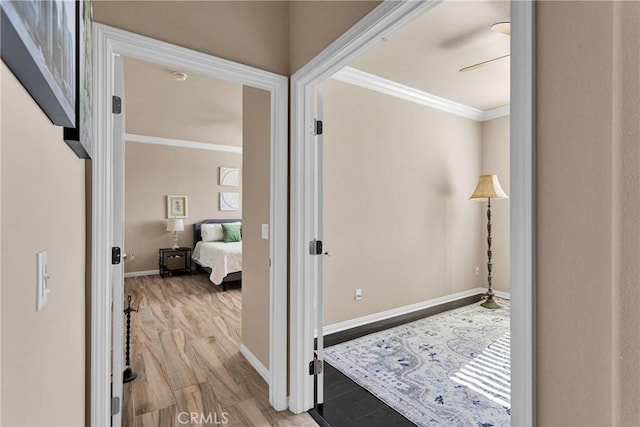 corridor with baseboards, crown molding, and wood finished floors